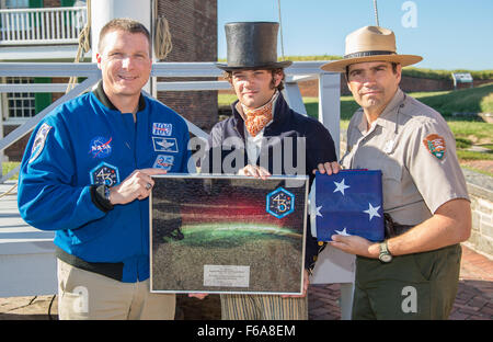 L'astronaute de la NASA Terry Virts, gauche, présente une réplique de la Star Spangled Banner qui a été volé à bord de la Station spatiale internationale au cours des expéditions 42 et 43 de Tyler le vison, le National Park Service ranger portant l'uniforme de la guerre de 1812 marin, centre, et Vince Vaise, National Park Service Fort McHenry, chef de l'interprétation au cours d'une visite à Fort McHenry National Monument historique et lieu de culte : le lundi, 15 septembre 2015 à Baltimore, Maryland) Crédit photo : NASA/Joel Kowsky) Banque D'Images