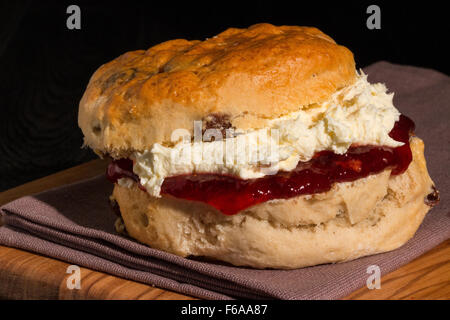 Et fraîchement cuits servis scone plein de délicieuse confiture de fraise et crème caillée Cornish Banque D'Images