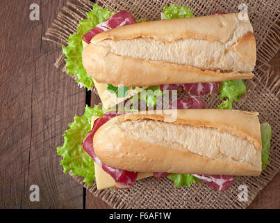 Big sandwich avec de la viande fumée sur un fond de bois Banque D'Images