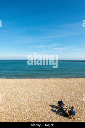 Regardant vers le bas sur un pique-nique en famille sur une plage de galets en pierre Banque D'Images