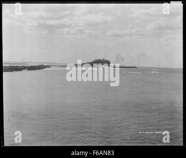 Photographie en noir et blanc de Nobbys et de l'entrée du port de Newcastle, prise depuis Fort Scratchley en Nouvelle-Galles du Sud. L'image capture la vue côtière emblématique, avec une importance historique liée à la défense et à l'histoire maritime de la région au début du XXe siècle. Banque D'Images