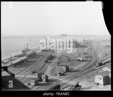 Photographie en noir et blanc montrant Nobbys Head et l'entrée du port depuis Customs House, Newcastle, Nouvelle-Galles du Sud. Cette image historique souligne l'importance du port et son rôle dans l'histoire maritime de la région. Banque D'Images