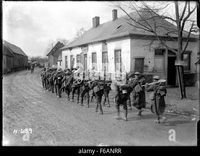 Cette photographie en noir et blanc montre un groupe de travail néo-zélandais marchant à Courcelles, en France, pendant la première Guerre mondiale. Elle capture les efforts des soldats néo-zélandais sur le front occidental. Banque D'Images