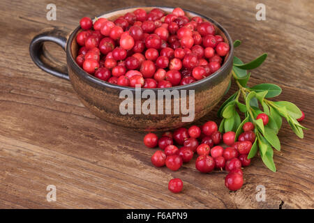 Tasse avec canneberge ou airelle rouge sur la vieille Table en bois Banque D'Images