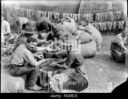 Cette photographie de la première Guerre mondiale montre des soldats en France lavant leurs chaussettes, capturant la vie quotidienne et les épreuves des soldats pendant le conflit. Il reflète les aspects difficiles et souvent négligés du service militaire dans les tranchées. Banque D'Images