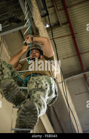 Spécialiste de la communication de masse 2e classe Anthony Martinez, affectés à la Caméra de combat expéditionnaire (ECC), monte une échelle spéléo de la Caméra de combat de la flotte au cours de l'été du Pacifique Plan Rapide 2015 domaine interarmées d'entraînement à Long Beach, Californie, le 7 août, 2015. Plan rapide est un exercice qui améliore le service de Caméra de combat la capacité des membres d'opérer dans un environnement tactique. Banque D'Images