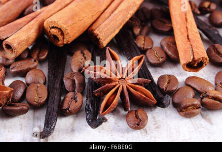 Parfumée fraîche gousses de vanille, cannelle, l'anis étoilé et les grains de café sur la vieille planche surface rustique en bois, Banque D'Images