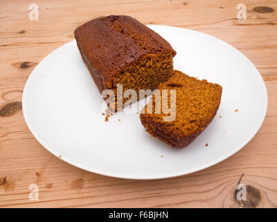 Yorkshire Parkin ou Perkin un gâteau traditionnel à base de mélasse d'avoine et le gingembre plaque blanche table en bois coupé en tranches Banque D'Images