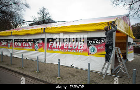 Hanovre, Allemagne. 16 Nov, 2015. Un homme construit une équipe nationale allemande tente fan club à l'IDH Arena de Hanovre, Allemagne, 16 novembre 2015. Le match de football entre l'Allemagne et les Pays-Bas se déroule à Hanovre le 17 novembre 2015. Il y a des précautions de sécurité accrue pour le jeu trois jours après les attentats à Paris. Photo : JULIAN STRATENSCHULTE/dpa/Alamy Live News Banque D'Images