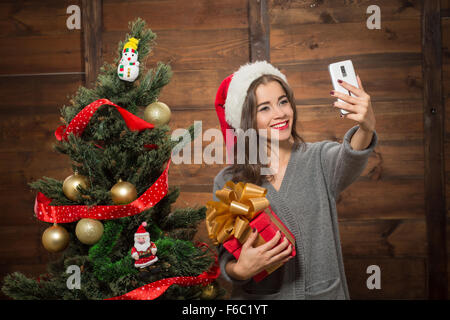 Belle fille faire autoportraits près de Nouvel An des arbres Banque D'Images