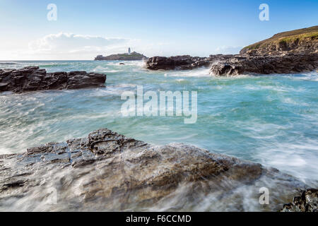 Les vagues déferlent sur les rochers au Godrevy Point, à l'extérieur, vers le phare sur l'île de Godrevy, Cornwall, Angleterre Banque D'Images