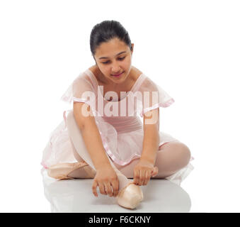 Jeune danseur en nouant ses chaussures pour danser sur fond blanc. Banque D'Images