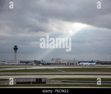 La piste de l'aéroport de Gatwick et tour de contrôle de la lumière par un arbre de lumière du soleil. Banque D'Images