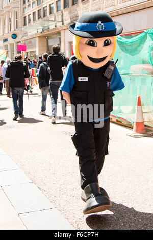 La police souriant femme marche dans la rue. Banque D'Images