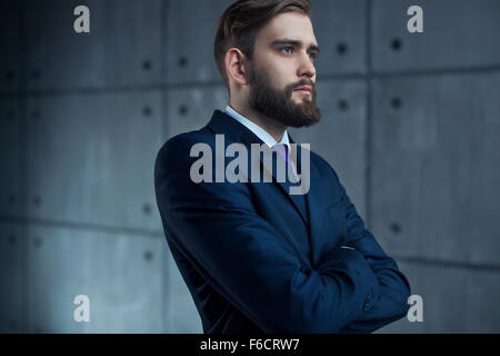 Young handsome man with beard en costume noir à l'extérieur à la fenêtre. Banque D'Images