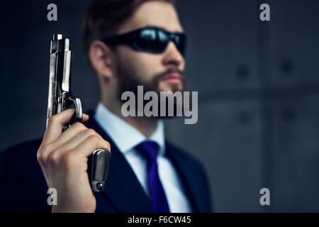 Danger man agent avec arme et lunettes de soleil. Se concentrer sur l'arme. Banque D'Images