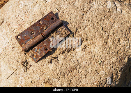 Old rusty de charnière d'une porte sur une pierre. Banque D'Images