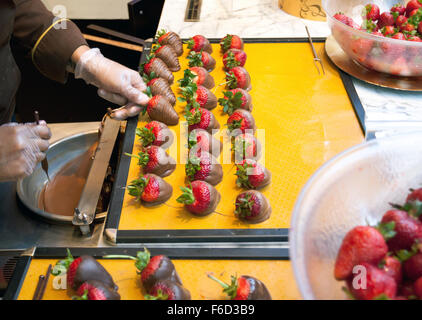 La fabrication du chocolat fraises trempées, New York. Banque D'Images