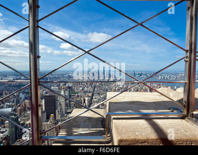 Vue de Manhattan depuis le dernier étage de l'Empire State Building de derrière le grillage de protection, New York City Banque D'Images