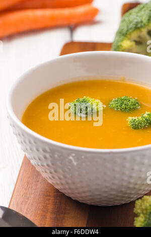 Crème de légumes soupe décoré avec des morceaux de chou-fleur, dans le bol blanc servi dans le restaurant de style eco table. Banque D'Images