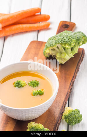 Crème de légumes soupe décoré avec des morceaux de chou-fleur, dans le bol blanc servi dans le restaurant de style eco table. Banque D'Images
