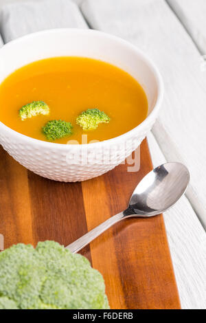 Crème de légumes soupe décoré avec des morceaux de chou-fleur, dans le bol blanc servi dans le restaurant de style eco table. Banque D'Images