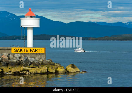 Bateau à moteur passant le phare Molde à l'entrée du port de Molde, Norvège Banque D'Images