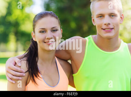 Heureux les amis ou les sportifs couple hugging outdoors Banque D'Images