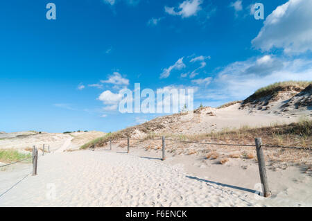 Ciel bleu avec quelques nuages sur sentier à travers les dunes de sable Banque D'Images