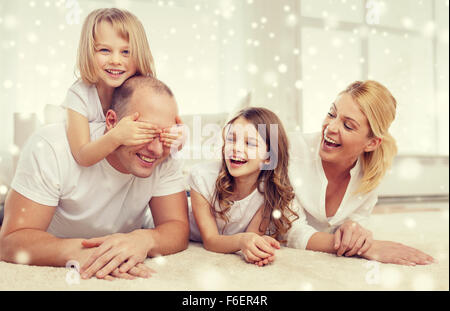 Smiling parents et deux petites filles à la maison Banque D'Images