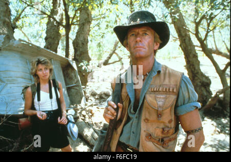 DATE DE SORTIE : Avril 30, 1986. Titre du film : Crocodile Dundee. STUDIO : Paramount Pictures. PLOT : New York Journaliste Sue se rend en Australie pour rencontrer et interviewer Michael J Crocodile Dundee, un homme qui dirige une entreprise de safari et a survécu à une attaque d'un crocodile. Après avoir passé quelques jours à visiter le parc safari, Sue Mick invite à revenir avec elle pour visiter New York. Comment le choc des cultures et différents style de vie affectent le bushman australien ? Comment faire les choses tourner quand Sue falls pour ses charmes ? Sur la photo : LINDA KOZLOWSKI que Sue Charlton, et Paul Hogan comme Michael J. 'Crocodile' Banque D'Images