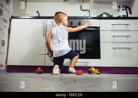 La prévention des accidents. L'enfant sans surveillance dans la cuisine avec une cuisinière à gaz. sans retoucher Banque D'Images