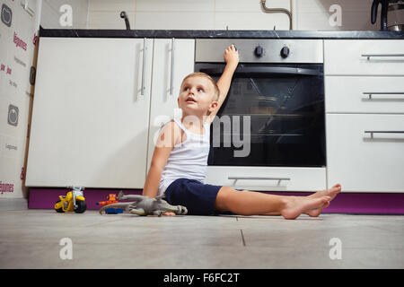 La prévention des accidents. L'enfant sans surveillance dans la cuisine avec une cuisinière à gaz. sans retoucher Banque D'Images