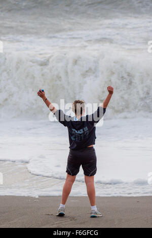 Pays de Galles Aberystwyth Uk, le mardi 17 novembre 2015 UK weather : Une jeune femme pose sur la plage comme derrière elle les vagues de la deuxième ouragan de la saison - Storm Barney - hits Aberystwyth, sur la côte ouest du pays de Galles. Rafales de vent devaient atteindre 80km/h sur les hauteurs, et les fortes pluies susceptibles de causer des inondations dans les zones déjà saturées après des jours de pluie Crédit photo : Keith Morris / Alamy Live News Banque D'Images