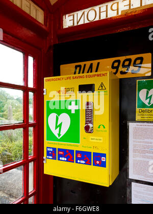 L'équipement de sauvetage d'urgence défibrillateur installé dans le vieux téléphone rouge fort dans le village d'Alport Derbyshire Dales England UK Banque D'Images