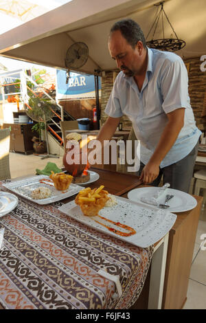 SIDE, TURQUIE - Juillet 07, 2015 : Le restaurant à côté, le serveur a servi la viande de la cocotte. Banque D'Images