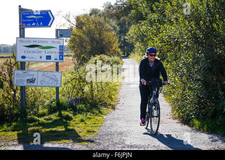 Un cycliste féminin bénéficie d'un jour d'automne chaud sur le chemin d'Ainsdale Cheshire Lines près de Merseyside. Banque D'Images