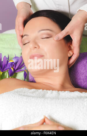 Femme ayant soin de beauté. Belle femme recevant un massage du visage, yeux clos, Close up Banque D'Images