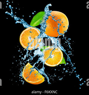Les oranges avec de l'eau splash sur le fond noir. Banque D'Images