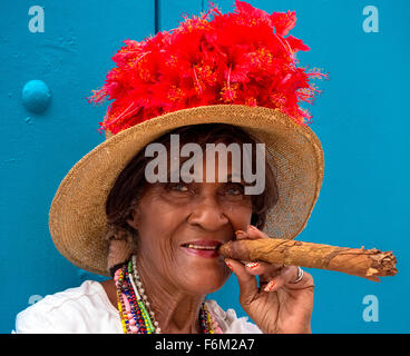 Vieille Femme cubaine fume dans la rue un cigare cubain et poster avec son chat pour les touristes, de Cuba, de l'Amérique du Nord, Caraïbes Banque D'Images