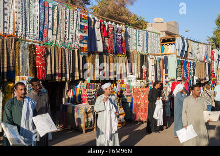 Piscine animé marché de souvenirs locaux à Edfu, Haute Égypte sur une journée ensoleillée avec ciel bleu, à vendre des tissus et des vêtements Banque D'Images