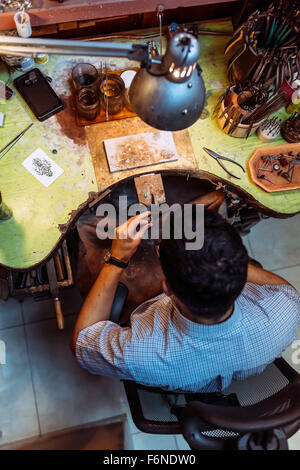 Artisan travaillant sur sa table de travail avec de nombreux outils Banque D'Images