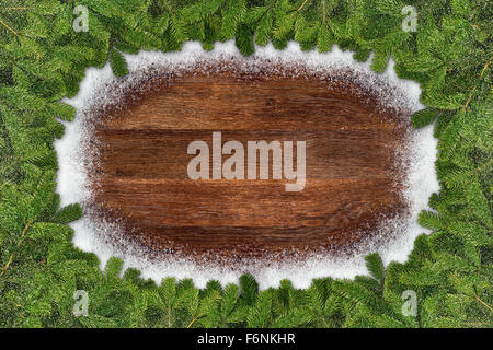 Branches de sapin sur fond de neige en bois du châssis Banque D'Images