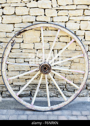 Old Vintage bois cassé roue en Provence sur un mur en pierre traditionnel. La France. Banque D'Images