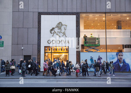 Les gens à pied par un magasin Godiva sur la 5e Avenue à Manhattan, New York. Banque D'Images