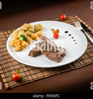 Steak de veau aux légumes sur la table prêt à manger Banque D'Images