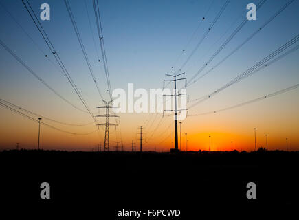 Silhouettes de ligne de transmission système de poteaux et les câbles contre beau soleil colorés (photo de nuit, l'éclairage au coucher du soleil Banque D'Images