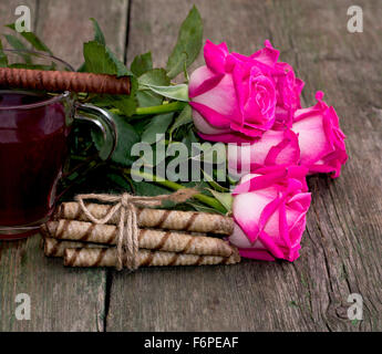 Bouquet de roses, cuisson et fragment d'une tasse de thé Banque D'Images