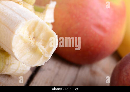 Mandarin les pommes et les bananes sur plaque de bois Banque D'Images