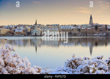 La ville de Reykjavik, le lac Tjörnin en automne après la chute de neige montrant le célèbre l'église Hallgrimskirkja sur l'horizon. Banque D'Images